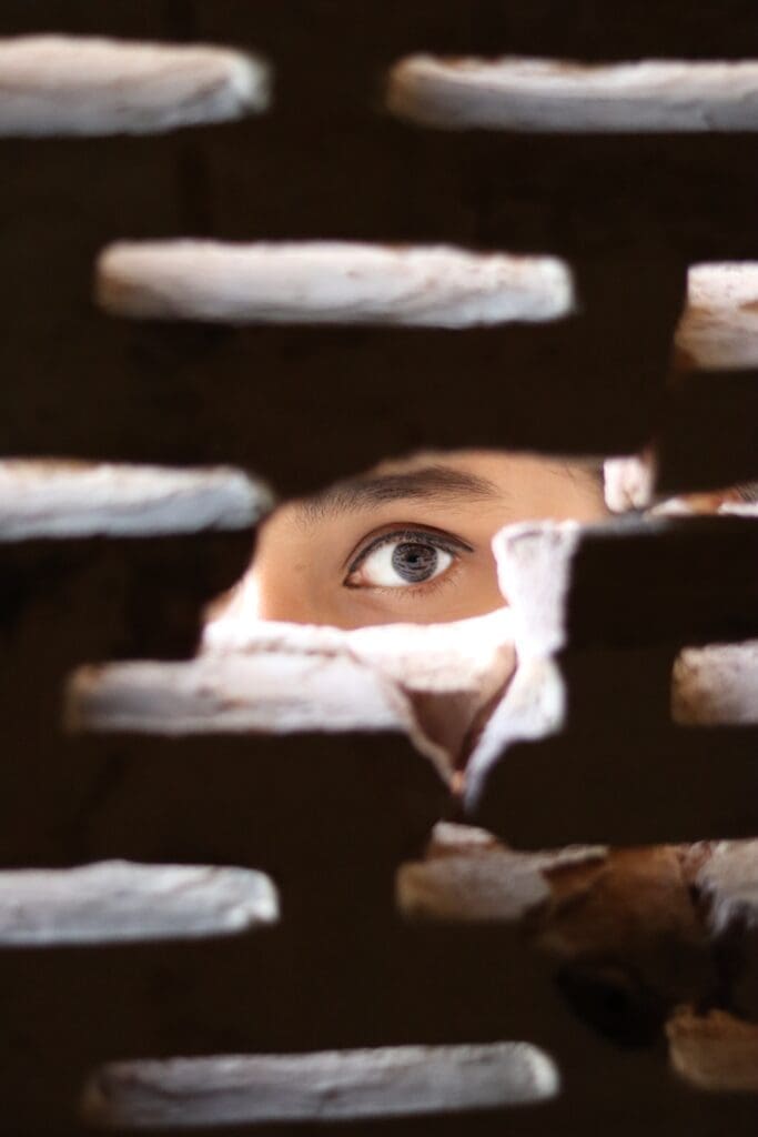 A person looks through a hole into a dwelling unit.